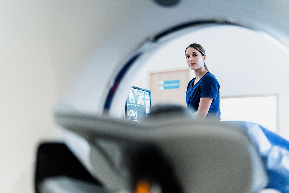 Technician looking into medical imaging device